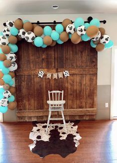 a chair sitting in front of a wooden door with balloons and decorations on the wall