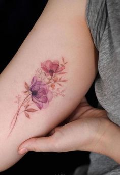 a woman's arm with flowers painted on it