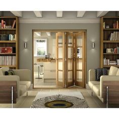 a living room filled with furniture and bookshelves next to a doorway that leads into a library