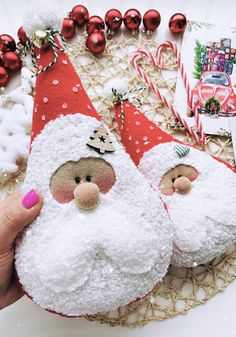 two santa claus ornaments sitting on top of a table