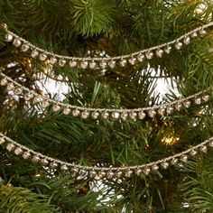 a close up of a christmas tree with lights and ornaments hanging from it's branches