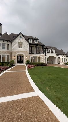 a large white house sitting on top of a lush green field