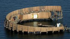 an aerial view of a floating structure in the water with people standing on it's sides