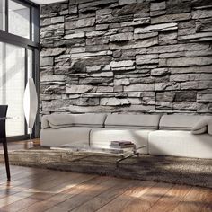 a living room with a stone wall and wooden flooring is shown in this image