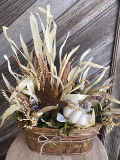 a basket filled with lots of white and brown flowers on top of a wooden table