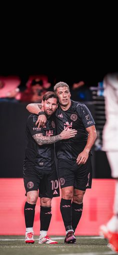 two soccer players hugging each other on the field