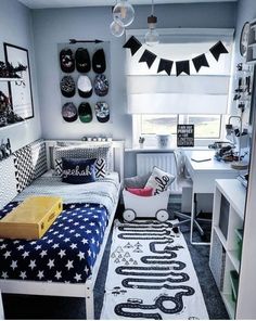 a room with a bed, desk and shelves filled with items on the wall next to it