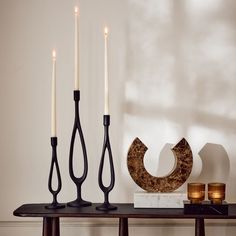 three candles are sitting on a table next to some decorative items