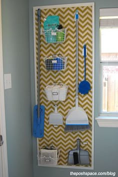 a wall mounted shelf with brooms and mop's on it