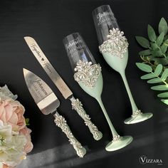 three wine glasses and two silverware are sitting on a table next to some flowers