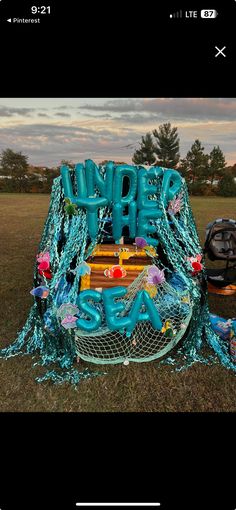 an image of a sign that is in the grass with chains and letters on it