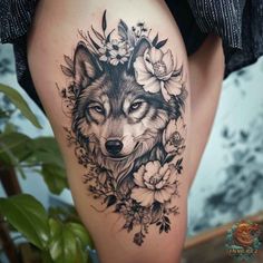 a woman's thigh with a wolf and flowers tattoo on the side of her leg