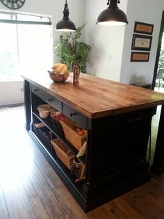 a kitchen island with baskets on it and hanging lights