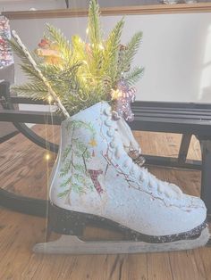 a pair of ice skates decorated with christmas lights and greenery sits on a wooden floor