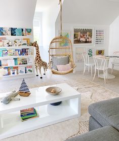 a living room filled with furniture and a giraffe figurine hanging from the ceiling