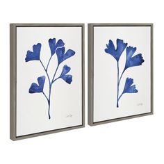 two framed art pieces with blue flowers painted on them, one is white and the other is gray