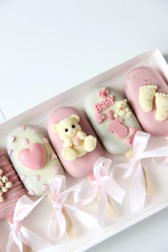 a pink and white box filled with different shaped cookies