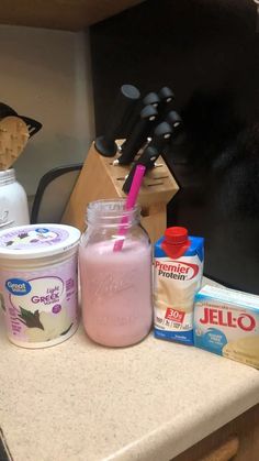 a counter with yogurt, milk and other items on it next to a blender