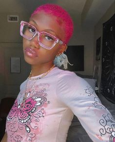 a woman with pink hair wearing glasses