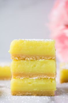 three lemon bars stacked on top of each other with the words vegan lemon bars above them