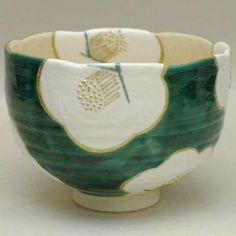 a green and white bowl sitting on top of a table