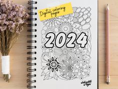 a notepad with the words 2021 on it next to a bouquet of flowers and a pen