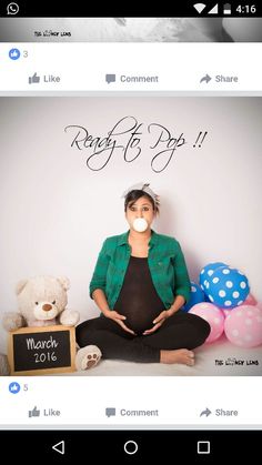 a woman is sitting on the floor with her stomach in front of balloons and a teddy bear