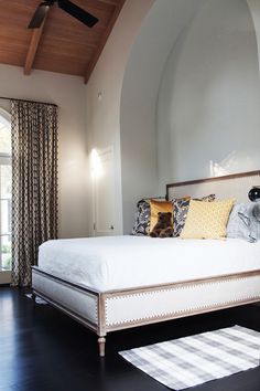 a bedroom with a bed, rugs and ceiling fan in it's center