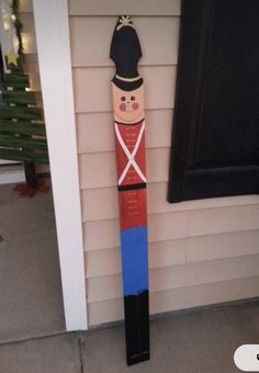 a wooden nutcracker standing in front of a door on the side of a house