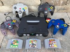 several video game controllers sitting next to each other on the ground with games in front of them