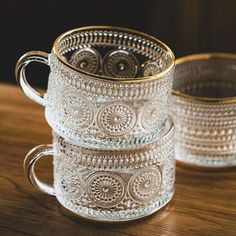 two glass mugs sitting on top of a wooden table