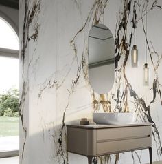 a white sink sitting under a bathroom mirror next to a wall mounted faucet