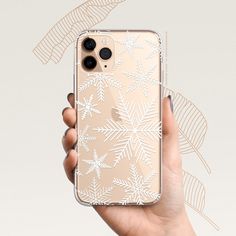 a person holding an iphone case with snowflakes on it