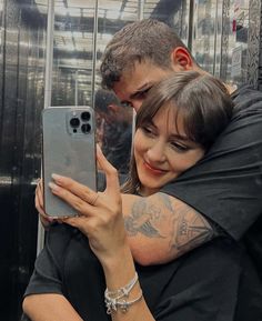 a man and woman taking a selfie with their cell phones