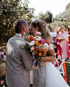 the bride and groom are kissing at their wedding ceremony