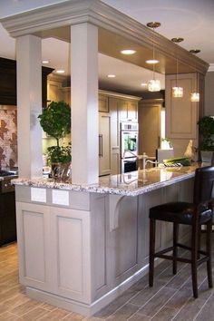 a large kitchen with an island in the middle and two bar stools next to it