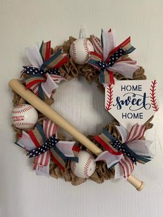 a wreath made out of burlocks and baseballs with a home sweet sign on it