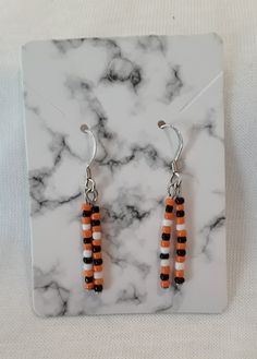 Halloween Earrings.  Beaded glass earrings alternating orange, black and white dangle from silver wires.  Two rows of beads hang from each wire swaying freely with Halloween colors.  These earrings are great to wear in October for the Halloween spirit, but also can be worn with everyday colors of orange or black.  Costume Earrings, Trick or Treat earrings, fun earrings, Fall Earrings. Purchase yourself or as a gift, think Teacher gift or just to say a Halloween "Thank You".  Handmade earrings  and FREE SHIPPING! Orange Dangle Beaded Earrings With Black Beads, Orange Dangle Earrings With Black Beads, Orange And Black Beads Dangle Earrings, Orange Earrings With Black Beads For Gift, Orange Earrings With Black Beads As Gift, Orange Dangle Jewelry With Black Beads, Fall Earrings Diy, Halloween Earrings Diy, Halloween Beaded Earrings