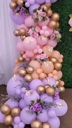 there is a tall cake made out of balloons and flowers on the top, along with other decorations