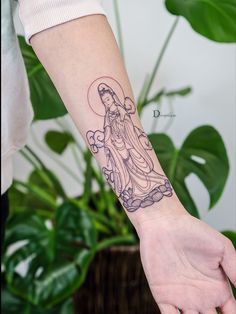 a woman's arm with a tattoo of a virgin mary on the left wrist