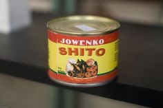 an open can of food sitting on top of a black table next to a window