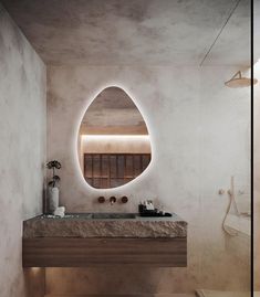 a bathroom with an oval mirror above the sink and marble counter top on the wall