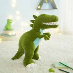 a stuffed toy dinosaur is sitting on the floor