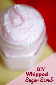 a jar filled with whipped sugar on top of a wooden table next to a pink and white sign