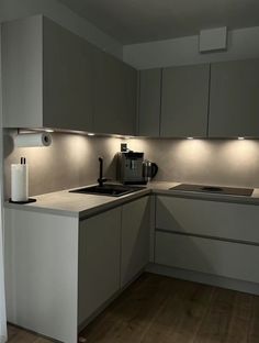 a kitchen that has some lights on the counter and cupboards in front of it