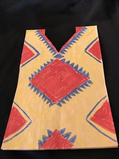 a piece of paper that has been made to look like an ornament with red, yellow and blue designs on it