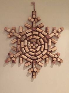 a snowflake made out of wine corks hanging on the side of a wall