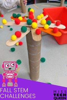 a paper tube with some colorful balls on it and a stick in the shape of a robot