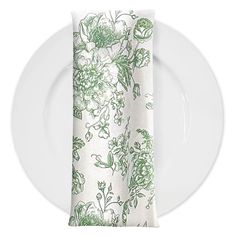 a white plate topped with a napkin covered in green and white floral print on it