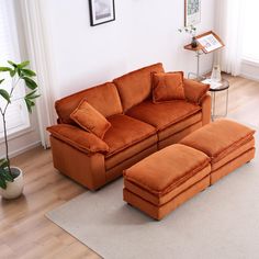 an orange couch and ottoman in a living room